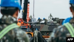 台湾国防部2024年12月16日发布照片显示，台湾士兵在新竹陆军装甲训练中心将一辆美制M1A2艾布拉姆斯主战坦克固定到一辆拖车上。台湾已从美国接收了38辆艾布拉姆斯主战坦克，以增强其军事能力应对中国的潜在攻击。