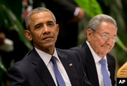 President Barack Obama, left, listens to a live band along with Cuba's President Raul Castro during a state dinner at the Palace of the Revolution in Havana, Cuba, March 21, 2016.