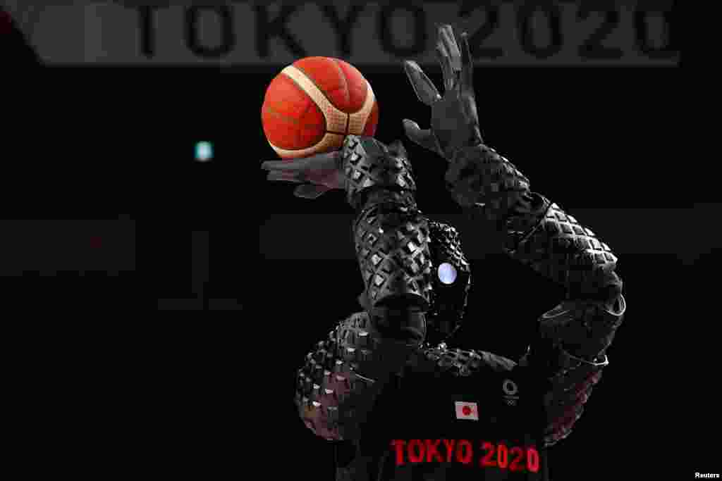 A Japanese basketball robot shoots the ball during half time of the women's game between Belgium and Puerto Rico during the Tokyo 2020 Olympics at Saitama Super Arena, in Saitama, Japan.