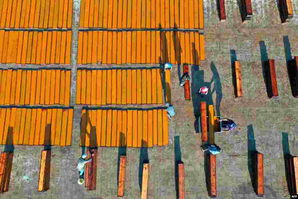 Syrian youths from the eastern Ghouta region on the outskirts of Damascus prepare strips of dried apricot paste, for making the Qamar al-Din drink their region is famous for producing, in Binnish in Syria's rebel-held northwestern province of Idlib.