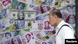 在香港的外汇商店，一名男子走过一个宣传中国人民币（RMB）和其他外国货币兑换服务的橱窗（2015年8月13日）。