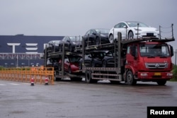 一辆大卡车运出特斯拉上海工厂出产的汽车。（2021年5月13日）