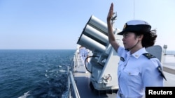 资料照：中国海军女兵在中俄海军在广东湛江举行的联合海军演习结束时向俄罗斯军人挥手致意。（2016年9月19日）