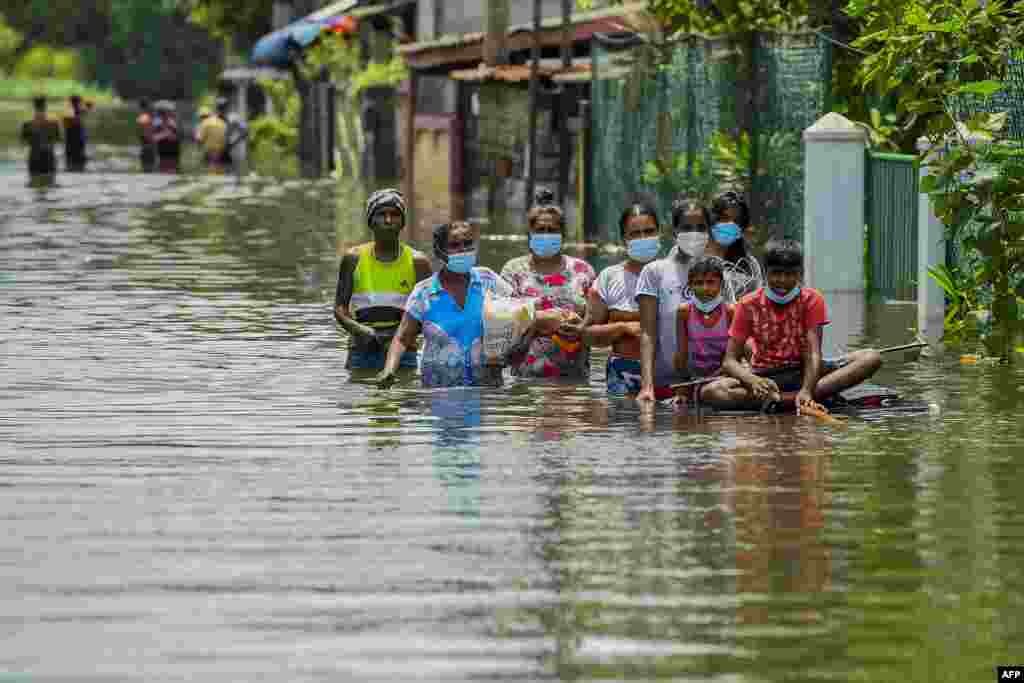 Residents make their way through floodwaters after heavy monsoon rains in Kelaniya, on the outskirts of Colombo, Sri Lanka.