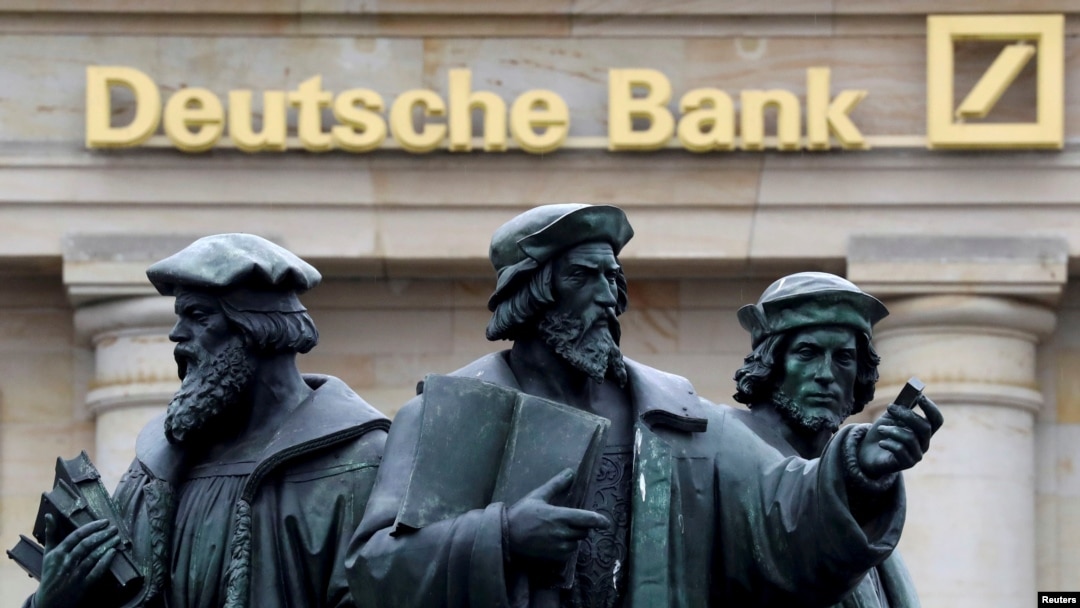 A statue stands next to the logo of Germany's Deutsche Bank in Frankfurt, Germany, Sept. 30, 2016.