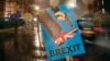 Vehicles drive past an anti-Brexit placard that is placed near the Parliament in London, Jan. 29, 2019.