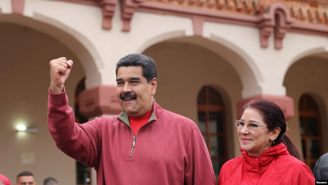 FILE - Venezuela's President Nicolas Maduro greets supporters with his wife Cilia Flores during an appearance at a military base in Caracas, Dec. 8, 2016.