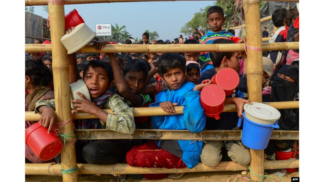 Rohingya refugees wait for food aid at Thankhali refugee camp in Bangladesh's Ukhia district on January 12, 2018.