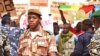 A national guard soldier walks by demonstrators at Bamako airport, Mali. (VOA - N. Palus)