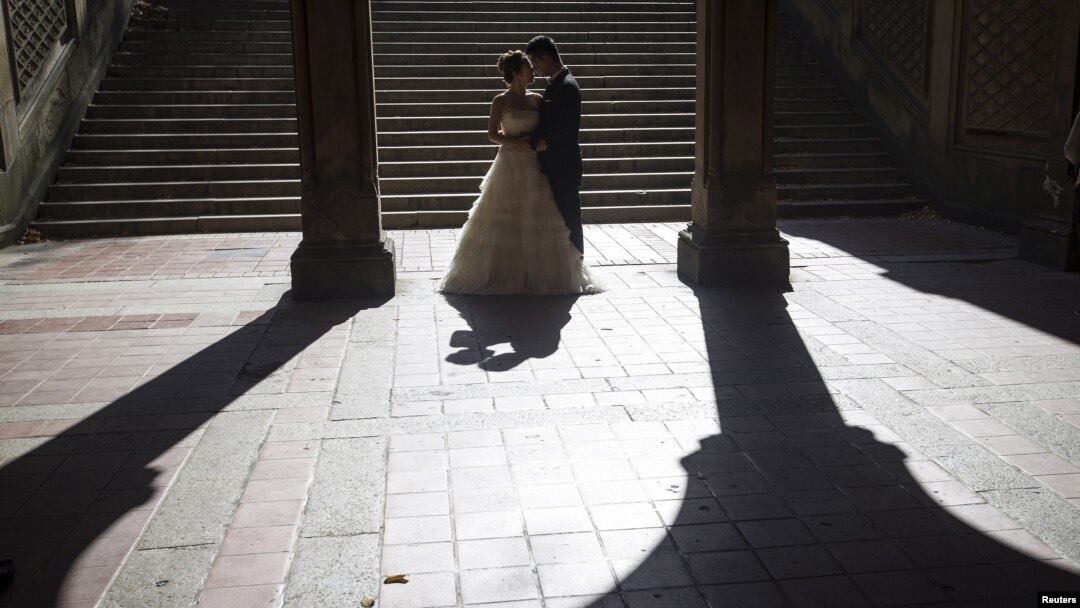 FILE - Jun Liu poses for a photo with his bride Seogyeong Choi during a wedding photoshoot at Bethesda Terrace in the Manhattan borough of New York, Oct. 20, 2015. 