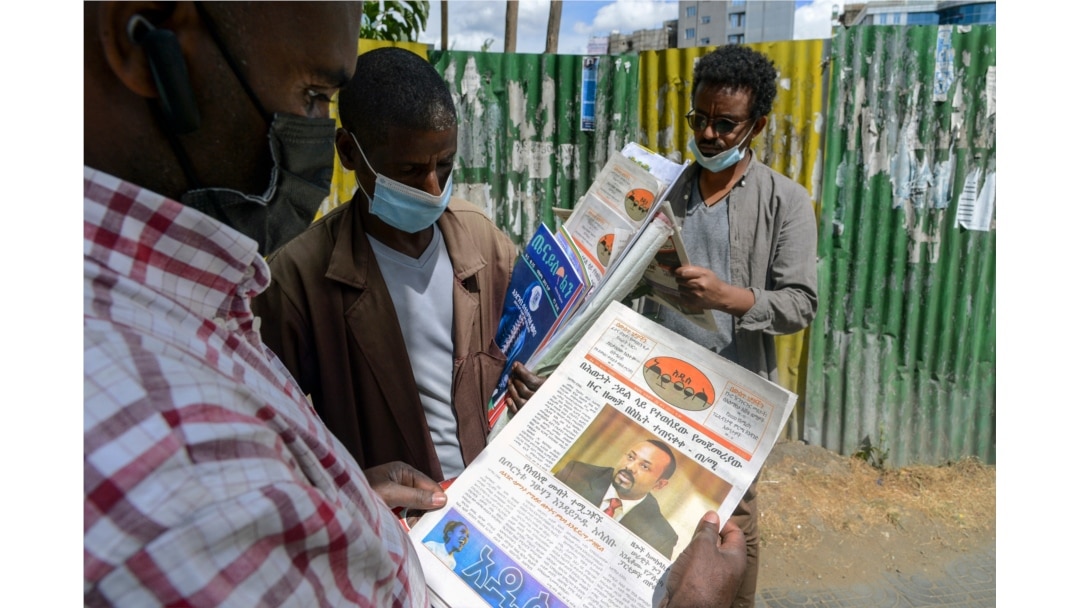 Ethiopians read about the military confrontation in the country, on a street in the capital Addis Ababa, Ethiopia, Nov. 7, 2020.