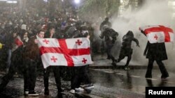 Правоохоронці застосовують водомети біля парламенту Грузії, щоб розігнати протест прихильників проєвропейського курсу країни, котрі вийшли на вулиці проти рішення нового уряду призупинити переговори про вступ до ЄС до 2028 року. REUTERS/Irakli Gedenidze