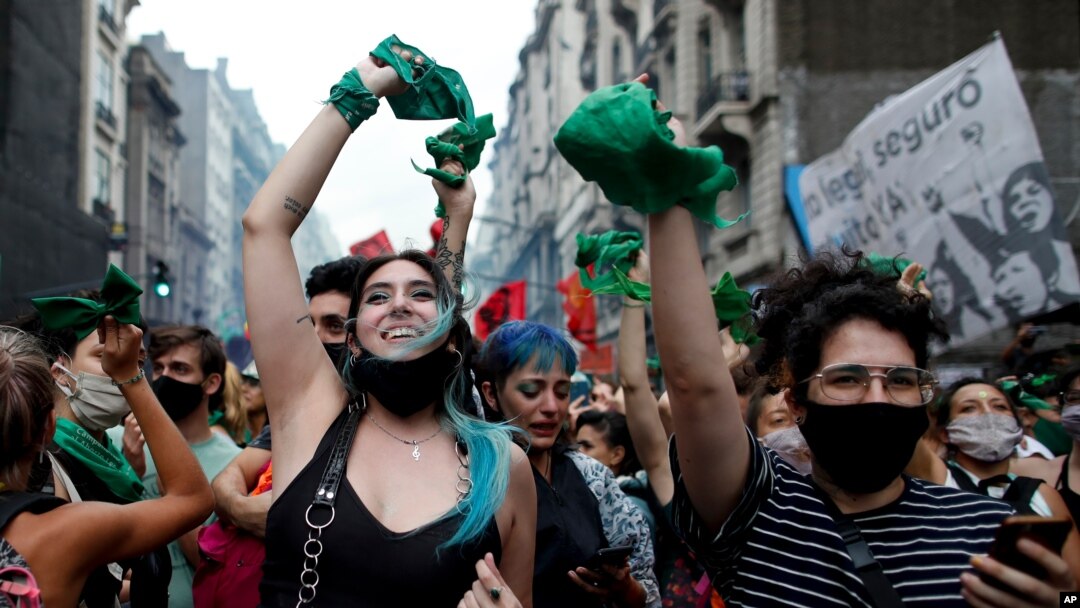 Abortion-rights activists celebrate as Argentine lower house approves a bill that would legalize abortion outside Congress in Buenos Aires, Argentina, Dec. 11, 2020. The bill now moves to the Senate.