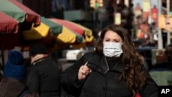 2020年1月30日，一名医药公司女职员在纽约街头行走。她说戴口罩是因为担心感染新冠状病毒。