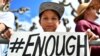 FILE - Zachary Chakin holds a sign as crowds participate in the March for Our Lives rally in support of gun control, March 24, 2018, in San Francisco.