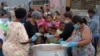 Children line up for food at a feeding scheme during the fourth week of lockdown to contain the spread of coronavirus, in Lavender Hill, Cape Town, South Africa, April 21, 2020.