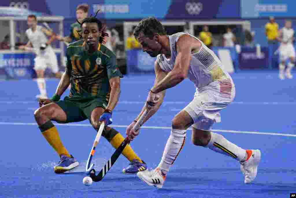 Belgium's Sebastien Dockier (9) drives up the pitch against South Africa's Tyson Dlungwana (3) during a Men's field hockey match at the 2020 Summer Olympics, Tuesday, July 27, 2021, in Tokyo, Japan. (AP Photo/John Minchillo)