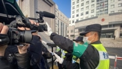 一名警察挡住记者的镜头阻止拍摄审讯公民记者张展的上海浦东新区法院外景。（法新社2021年12月28日）
