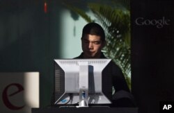 FILE - A man uses computer at the guests waiting area inside Google China's headquarters building in Beijing, China on Jan. 25, 2010.