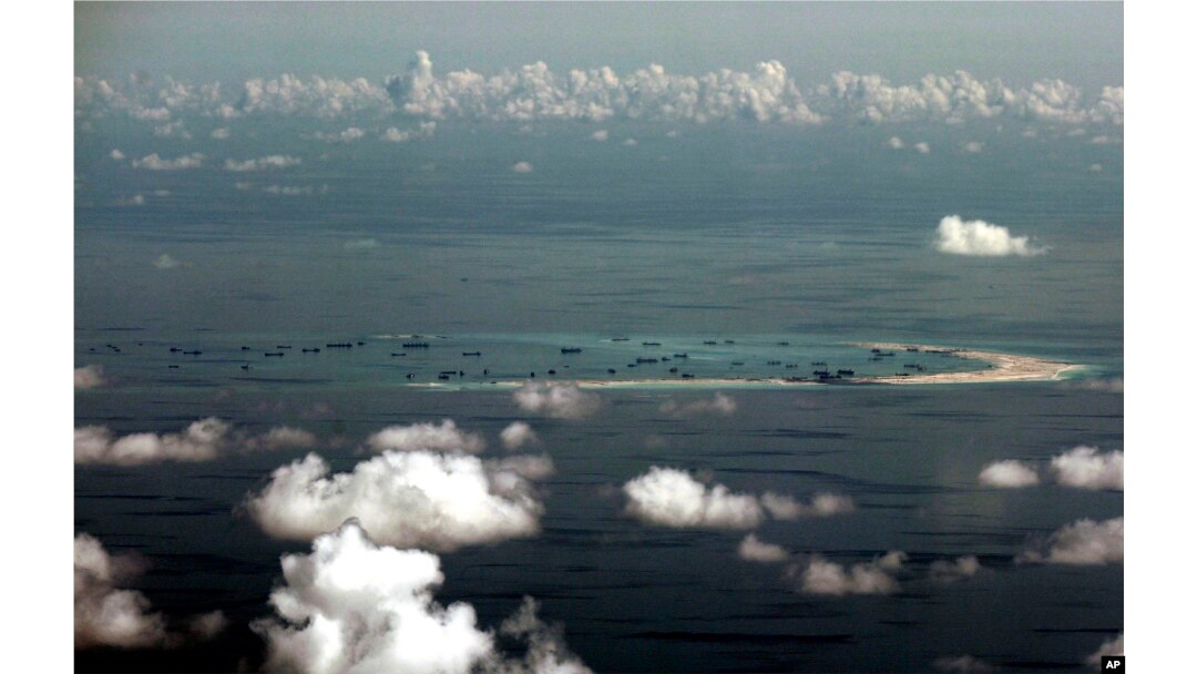 FILE - This aerial photo taken through a glass window of a military plane shows China's alleged on-going reclamation of Mischief Reef in the Spratly Islands in the South China Sea, May 11, 2015.