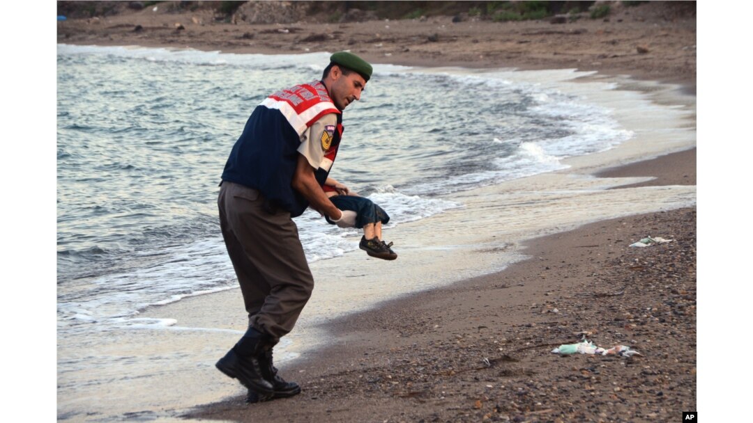 A paramilitary police officer carries the body of a migrant child after a number of migrants died and a smaller number were reported missing after boats carrying them to a Greek island of Kos capsized, near the Turkish resort of Bodrum, Sept. 2, 2015.