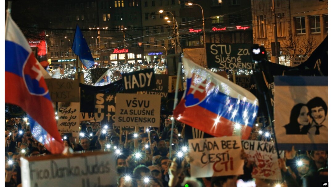 FILE - People flash the lights of their mobile phones as they celebrate the resignation of Prime Minister Robert Fico and his government during a rally in Bratislava, Slovakia, March 16, 2018.