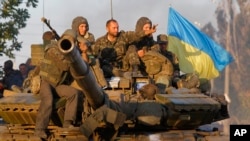 Soldiers of Ukrainian army ride on a tank in the port city of Mariupol, southeastern Ukraine, Sept. 5, 2014.