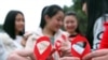 FILE - Volunteers take part in an event to mark World AIDS Day in Chongqing, China, Nov. 30, 2015. 