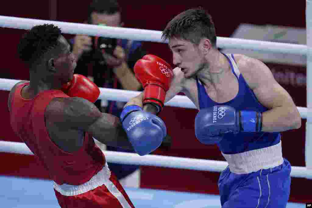 Uganda's Shadiri Bwogi, left, exchanges punches with Georgia's Eskerhan Madiev during their men's welterweight 69-kg boxing match at the 2020 Summer Olympics, Tuesday, July 27, 2021, in Tokyo, Japan. (AP Photo/Frank Franklin II)