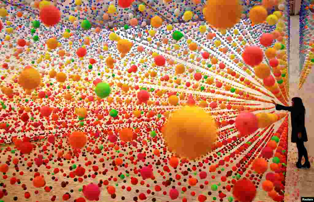 Australian artist Nike Savvas adjusts her installation artwork piece, consisiting of over 50,000 polystyrene balls, titled 'Atomic: full of love full of wonder' as it is installed for the upcoming exhibition 'Spacemakers and roomshakers: installations from the collection' at the New South Wales Art Gallery in Sydney, Australia.