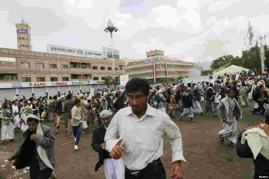 People flee at the scene of a suicide attack in Sana'a, Yemen, Oct. 9, 2014.