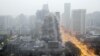 FILE - A building crumbles during a controlled demolition to make way for a new commercial center in Xi'an, Shaanxi province, China.