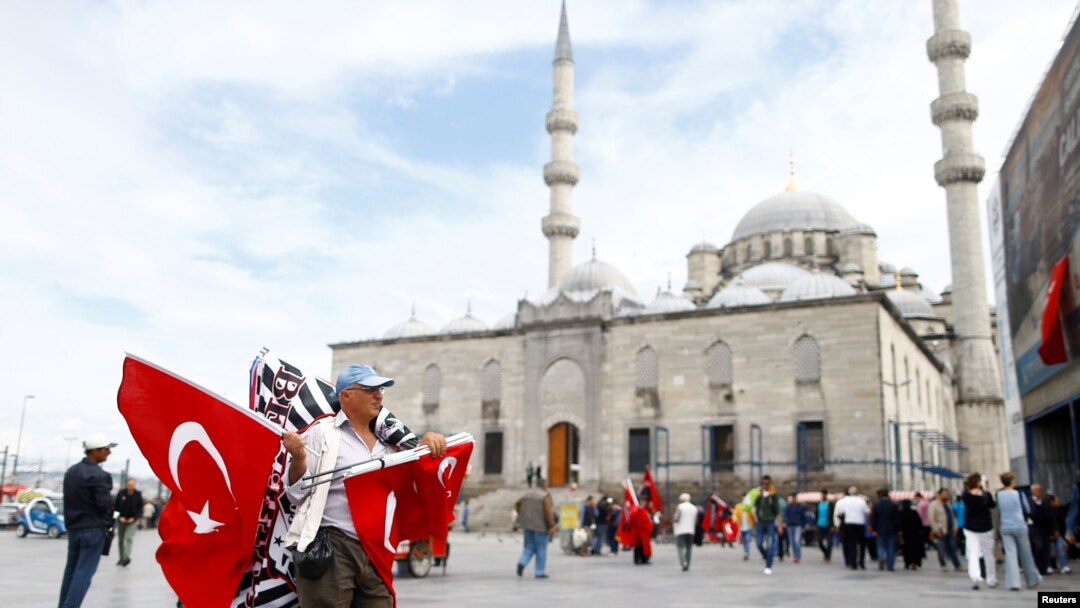 A flag seller waits for customers in front of the 17th century Ottoman era New Mosque (Yeni cami) in Istanbul, Turkey, May 4, 2016. 