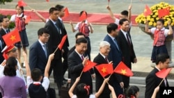 中国国家主席习近平和越南共产党总书记阮富仲前往参加会谈，向欢迎群众招手（2017年11月12日）