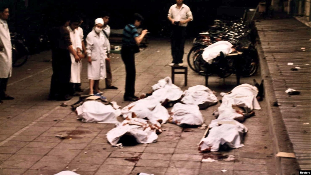 FILE: Medical workers at Beijing's Fuxingmen Hospital look at bodies of protesters killed by soldiers around Tiananmen Square on June 4, 1989.