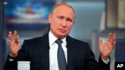 Russian President Vladimir Putin gestures answers a question during his annual call-in show in Moscow, Russia, June 7, 2018. 