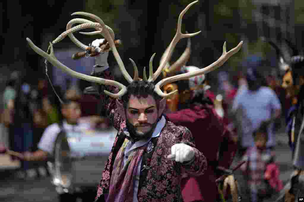 A costumed Indigenous man dances during a march in recognition of the International Day of the World's Indigenous Peoples in Mexico City, Aug. 9, 2021.