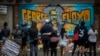 FILE - People are seen gathered at a memorial featuring a mural of George Floyd, near the spot where he died while in police custody, in Minneapolis, Minnesota, May 31, 2020.