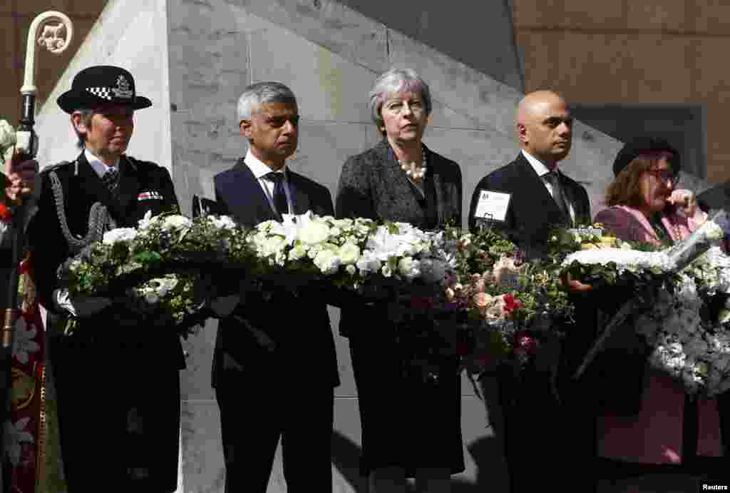 Britain's Prime Minister Theresa May, London's Mayor Sadiq Khan, Metropolitan Police Commissioner Cressida Dick and Home Secretary Sajid Javid hold wreaths during commemorations of the first anniversary of the attack on London Bridge, in London.