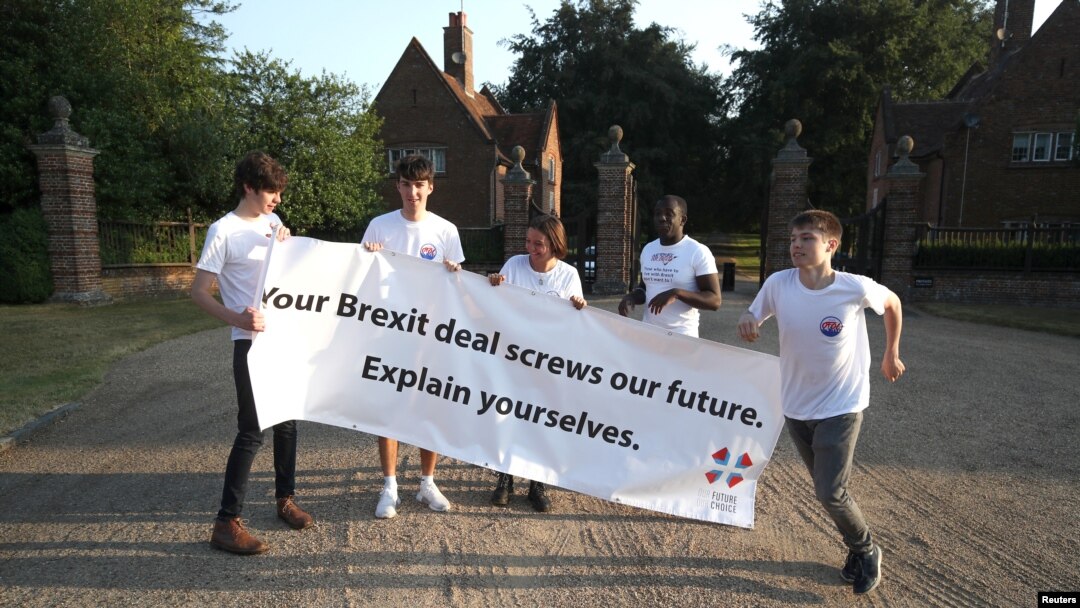 A small group of protesters, from a group called 'Our Future Our Choice', hold a banner at the gate house entrance to Chequers, the Prime Minister's official country residence, near Aylesbury, Britain, July 6, 2018. 