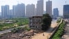 资料照：中国陕西西安市一个建筑工地的中央矗立着被拆了一半的楼房，里面居住着因拆迁纠纷拒绝搬走的一家七口人。（2013年8月14日）