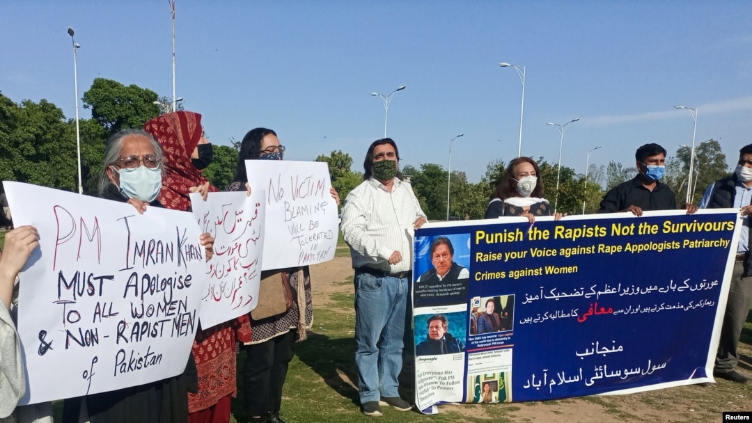 People carry signs as they condemn the remarks by Prime Minister Imran Khan, during a protest in Islamabad, Pakistan, April 8, 2021.