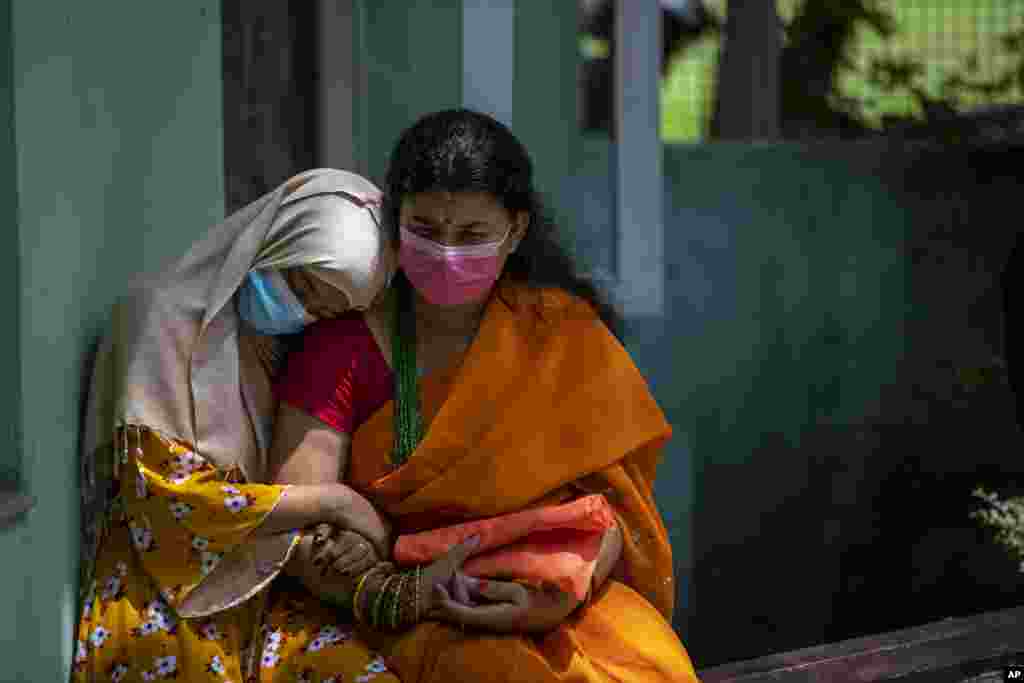 A physically disabled Nepalese girl waits with her mother to receive a dose of Johnson and Johnson vaccine at the Nepal Disabled Association Khagendra New Life Center in Kathmandu.