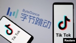 图为智能手机显示的TikTok应用软件标记，背景是北京的字节跳动公司标志（2019年11月27日）