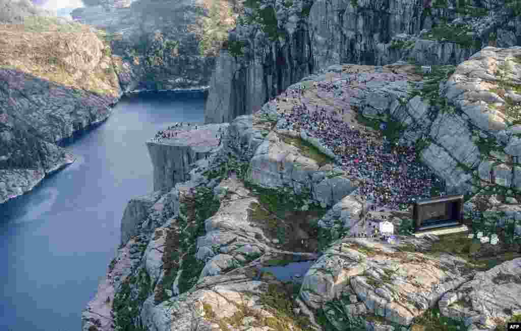 People gather in the mountains near Preikestolen (The Pullpit Rock) in Forsand near Stavanger, Norway, to see the movie "Mission: Impossible — Fallout," Aug. 1, 2018.
