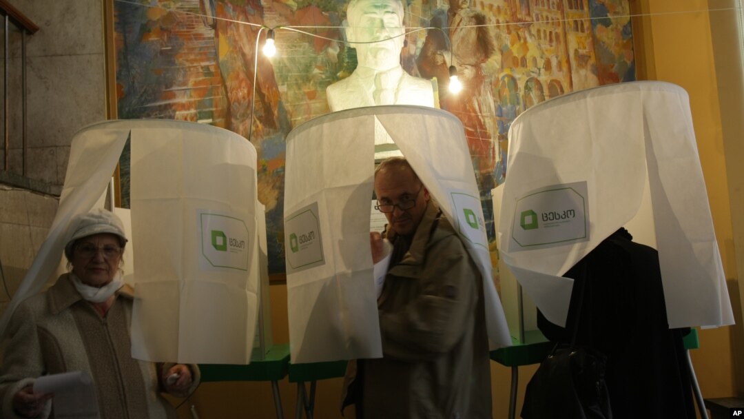 Georgians leave voting booths to cast their ballots during the presidential election in Tbilisi, Georgia, Oct. 27, 2013. 
