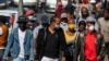 People wearing face masks to protect against coronavirus, walk on the street in downtown Johannesburg, South Africa, May 11, 2020. 