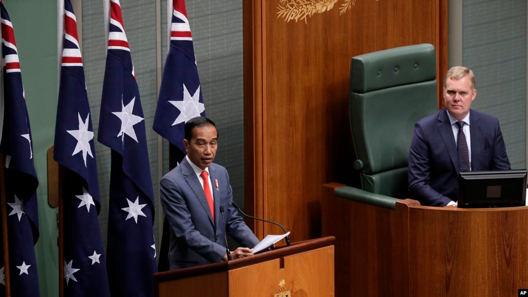 Indonesia's President Joko Widodo, left, address the Australian Parliament in Canberra, as the speaker of the house, Tony Smith, right, listens, Feb. 10, 2020. 