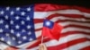 FILE - An anti-government protester holds a Taiwan national flag as a US flag flutters in the background during a demonstration to celebrate Taiwan's National Day in Hong Kong, China Oct. 10, 2019.