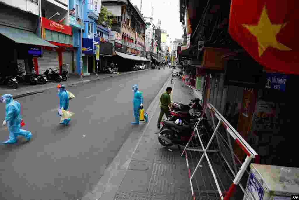 Medical workers collecting test samples from residents walk through Ho Chi Minh City on the first day of the government imposed two-week lockdown as a preventive measure to stop the spread of COVID-19.